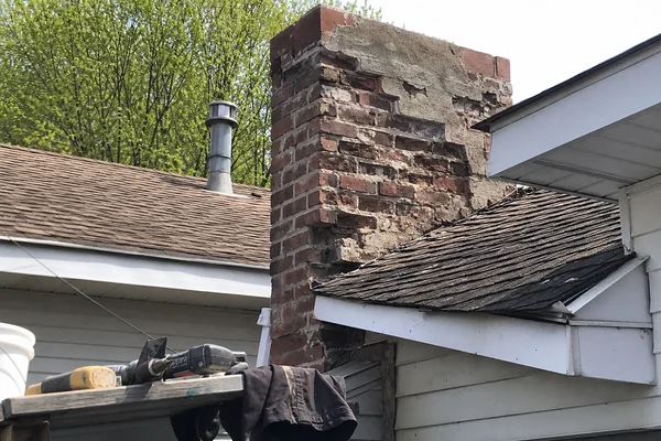 Deteriorating brick chimney showing spalling and crumbling mortar