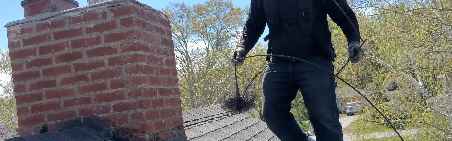 Chimney sweep finishing work on a New England home
