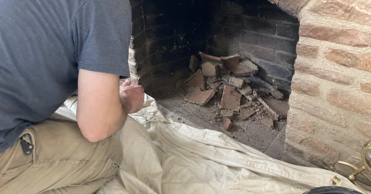 Broken clay flue tile shards in the bottom of a fireplace firebox