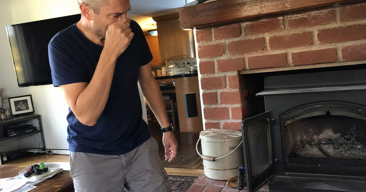 Homeowner near a fireplace noticing chimney odor
