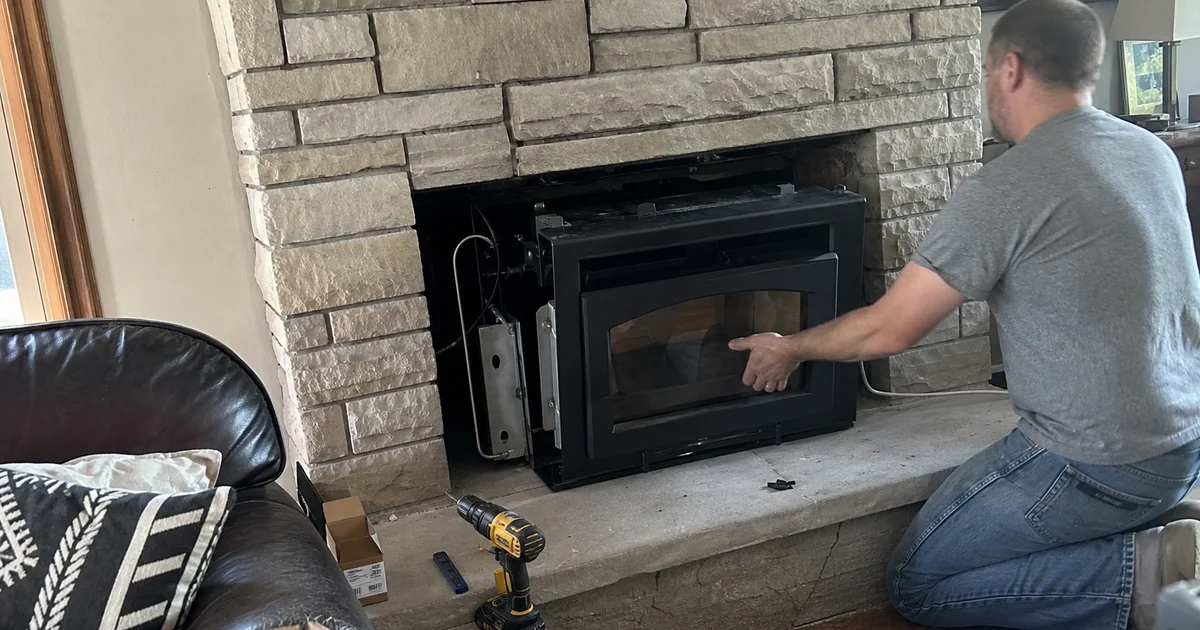 New fireplace insert being fitted into an existing masonry fireplace
