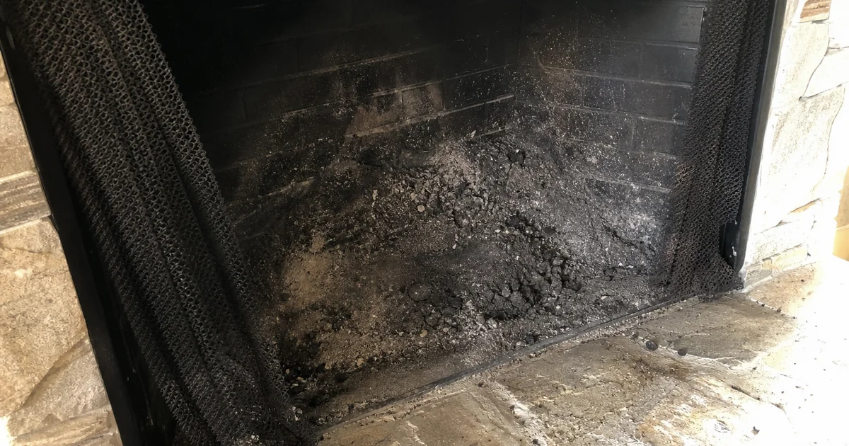 Soot and debris collected in the bottom of a fireplace firebox