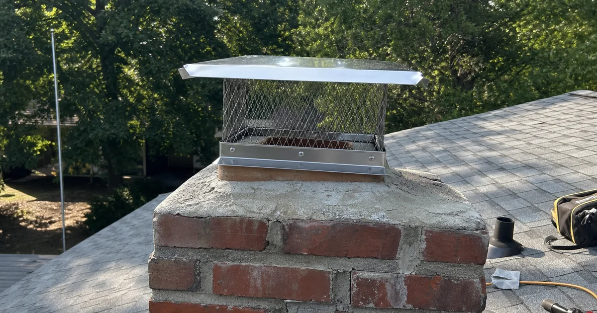 Stainless steel chimney cap installed on a brick chimney