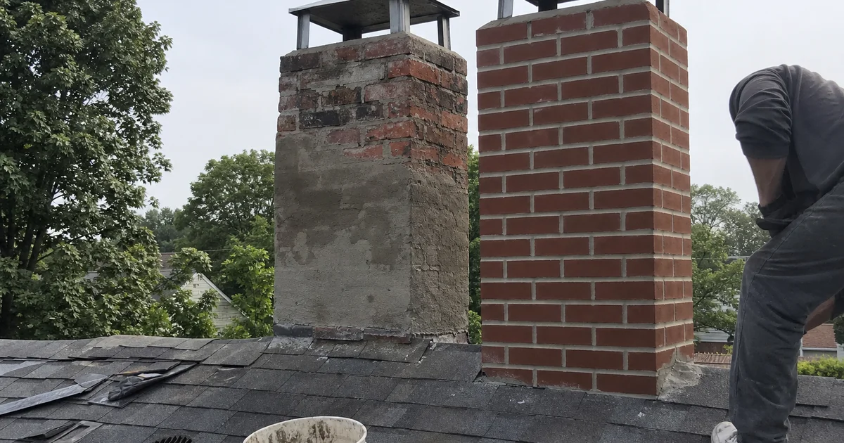 Two chimneys side by side, one partially repaired and one fully rebuilt