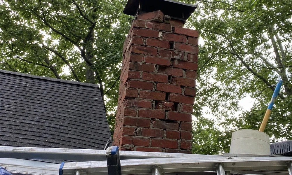Before photo of the deteriorating chimney with spalling bricks