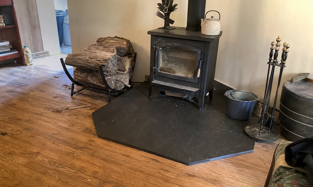 Code-compliant non-combustible hearth pad installed under a wood stove
