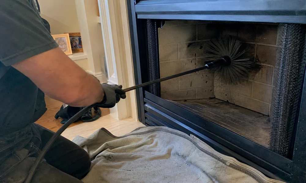 Rotary sweep brush removing glazed creosote from inside a chimney flue