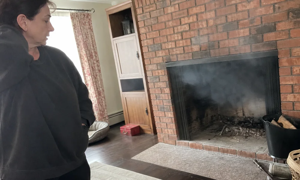 Smoke drifting back into a living room from a brick fireplace due to poor draft