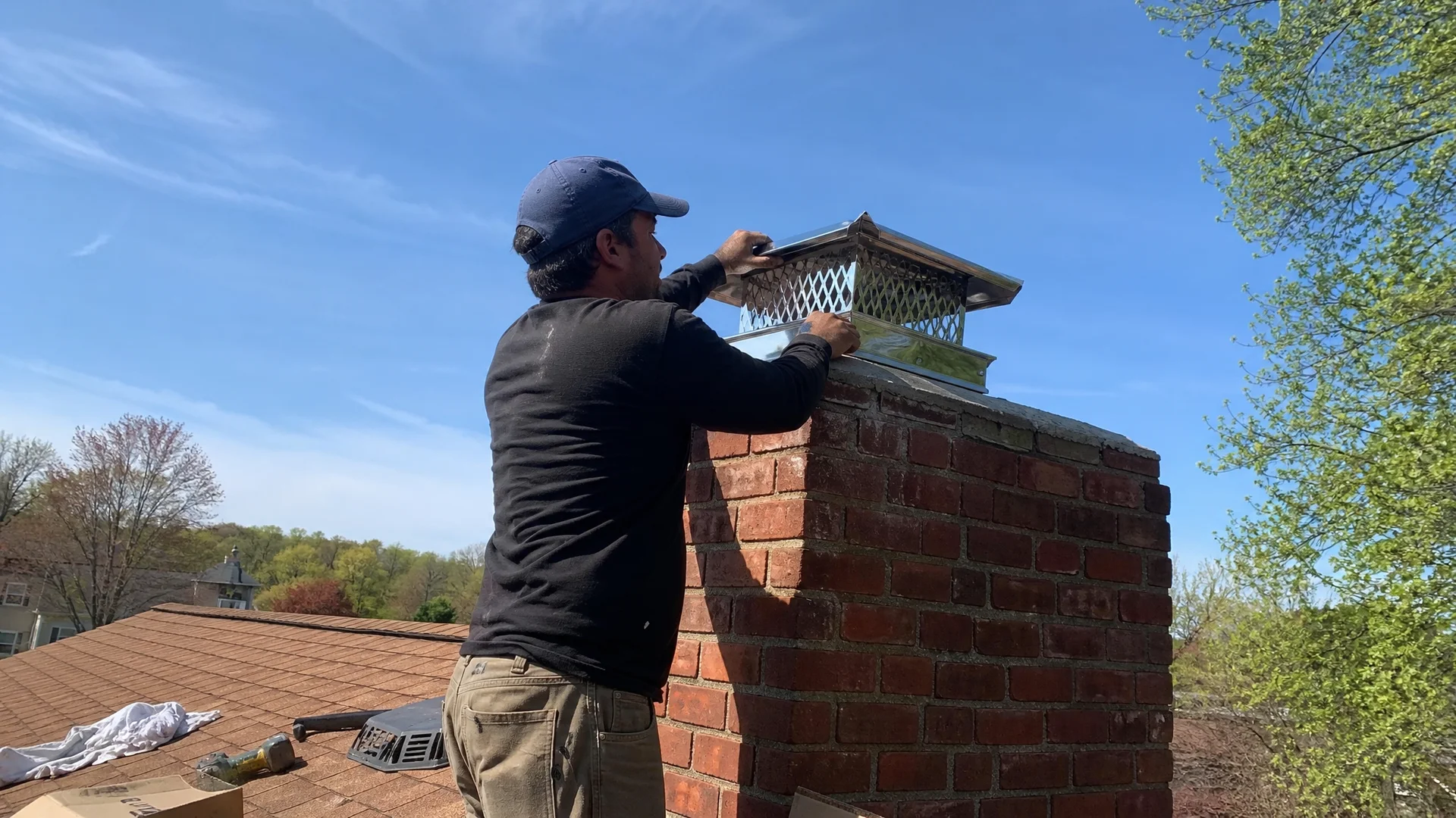 Stainless steel chimney cap installed at the top of a brick chimney