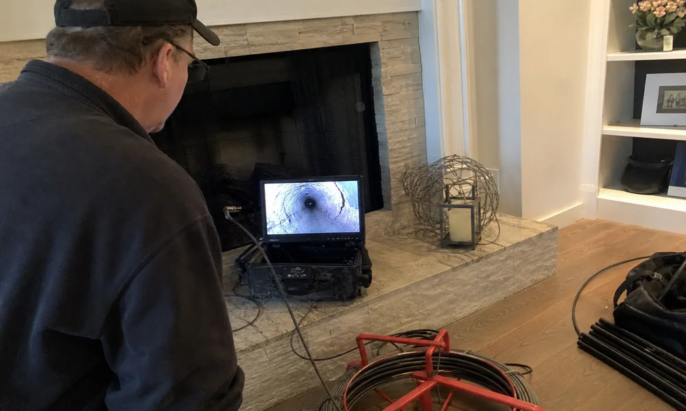 Technician viewing a cracked flue liner on a video-scan monitor