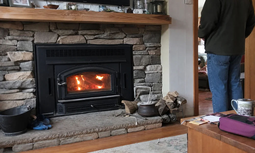 Wood-burning fireplace insert with glass door installed in a living room